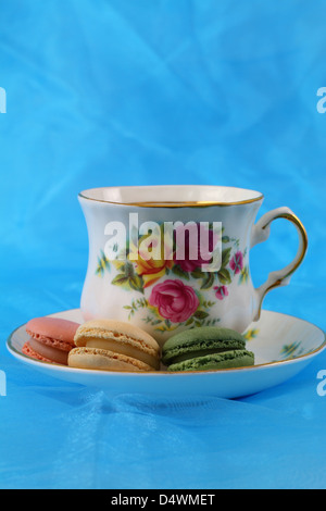 Gli amaretti e vintage tazza di porcellana su sfondo blu Foto Stock