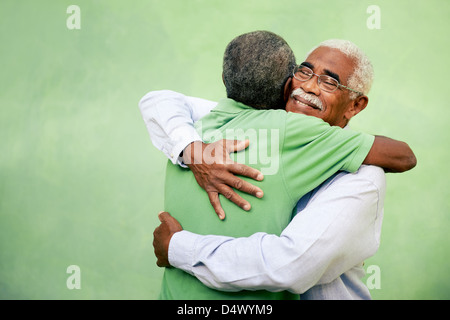 Attivi vecchi pensionati uomini e tempo libero, due senior fratelli nero abbracciando all'aperto Foto Stock