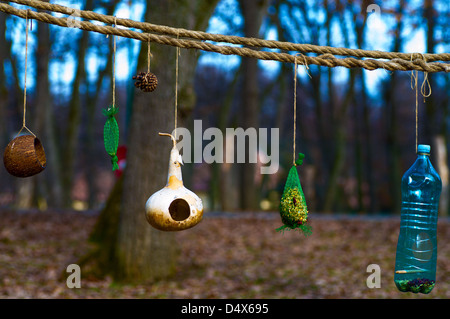 Gli alimentatori di uccelli da materiali riciclati appeso nella foresta Foto Stock