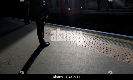 Persone in attesa sul binario alla stazione della metropolitana Barbican stazioni ferroviarie a Londra Inghilterra Regno Unito KATHY DEWITT Foto Stock