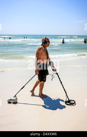 Uomo in pensione utilizzando un rilevatore di metalli su Siesta Key beach Florida durante le vacanze di primavera Foto Stock