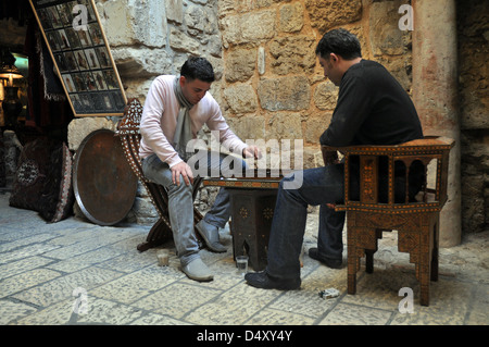 Negozio di arabi keeprs gioca a Backgammon nella parte anteriore del loro negozio, nel bazaar vecchia città, Gerusalemme, Israele Foto Stock