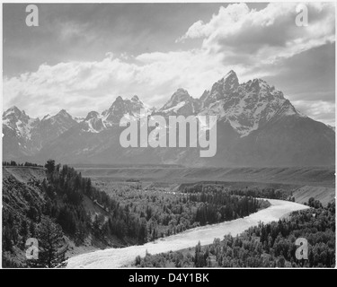 Una fotografia del Grand Teton National Park, Wyoming, di Ansel Adams, che mostra un fiume che scorre attraverso la valle con montagne innevate sullo sfondo. La vista cattura l'aspra bellezza della regione. Foto Stock