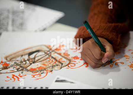 Uno studente estrae un design durante una classe di ceramica a Cardonald college di Glasgow. Foto Stock