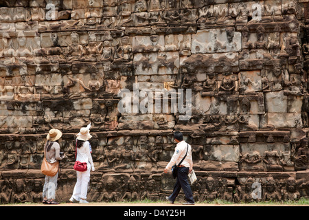 Tourist contemplando i rilievi sul lebbroso re terrazza. Angkor Thom. I templi di Angkor. Cambogia Foto Stock