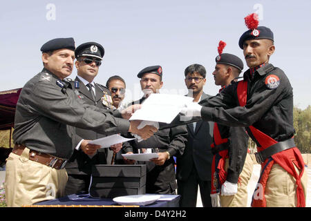 La polizia di Sindh ulteriori Ispettore Generale, Ghulam Shabbir Sheikh aggiudicazione certificati per i funzionari di polizia che hanno dimostrato la loro eccezionale impegno durante il servizio, durante il XVI passando dalla sfilata di Shaheed Benazir Bhutto Elite forza di polizia Training Center Razzaqabad a Karachi il Mercoledì, 20 marzo 2013 Foto Stock