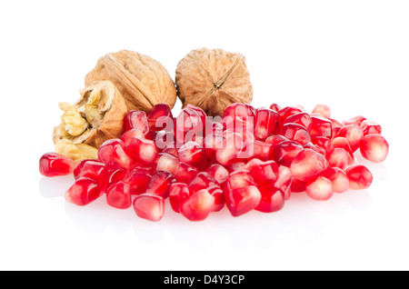 Semi di melograno pila e dadi isolati su sfondo bianco. Foto Stock