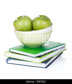 Mele Verdi in coppa di frutta e libri. Isolato su sfondo bianco Foto Stock