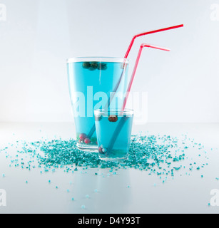 Due deliziosi cocktail blu in vetro con molti-perline colorate di rosso e puff Foto Stock