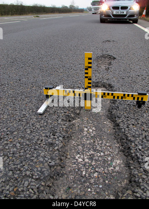 Buche, guasti meccanici, strumento di misura dei difetti, indagine, automobilisti, negligenza, danni, veicoli, lesioni personali, dovere di mantenere la strada. Foto Stock