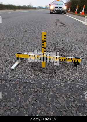 Buche, guasti meccanici, strumento di misura dei difetti, indagine, automobilisti, negligenza, danni, veicoli, lesioni personali, dovere di mantenere la strada. Foto Stock