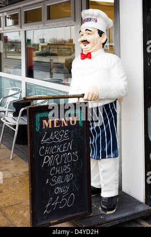 Lo Chef mannikin al di fuori di una caffetteria in Middlesbrough con una lavagna pubblicità un "grande Parmo pollo" una specialità locale piatto Foto Stock