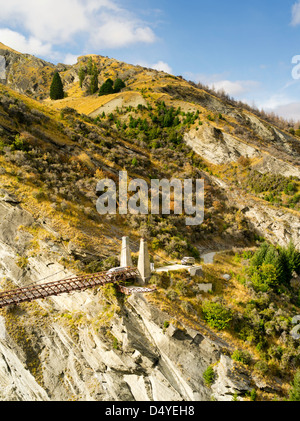 Due autobus turistici da Queenstown Heritage Tours attraversare un vecchio ponte di sospensione attraverso il fiume Shotover e Skipper's Canyon. Foto Stock