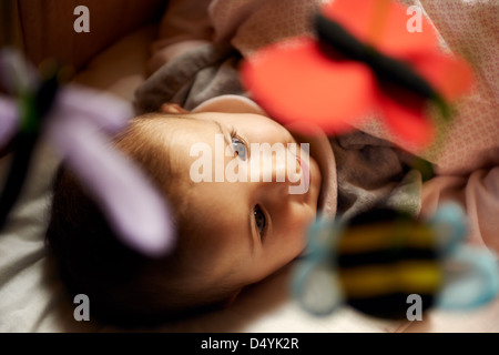 Bambini che giocano in casa felice incantevole piccola ragazza sorridente e giocare con i giocattoli e bambole in bed Foto Stock