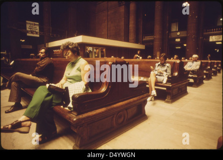 I passeggeri si rilassano sulle grandi panchine di legno della Chicago Union Station, fotografata nel giugno 1974. L'immagine evidenzia il design architettonico della stazione e lo spazio dei trasporti pubblici. Foto Stock