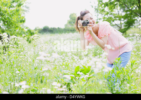 Donna Giapponese a scattare foto in un prato Foto Stock