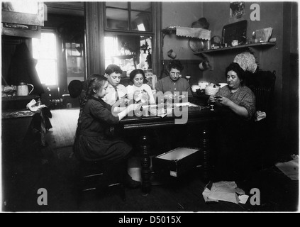Una foto del febbraio 1912 mostra una bambina di 11 anni e un ragazzo di 13 anni che fanno le cravatte nella loro cucina dopo la scuola. Questa immagine documenta le pratiche di lavoro minorile all'inizio del XX secolo. Foto Stock