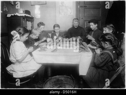 Rendendo giarrettiere. Una famiglia ebrea e vicini a lavorare fino a tarda notte, Febbraio 1912 Foto Stock