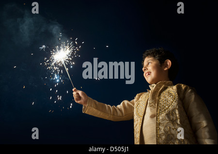 Ragazzo fuoco ardente cracker il Diwali Foto Stock