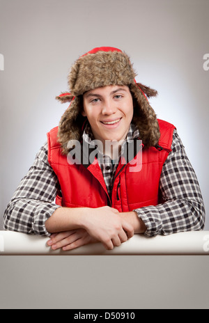 Ritratto di giovane sorridente uomo in un cappello di pelliccia e canotta. Foto Stock