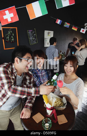 I giovani con un drink in un bar Foto Stock