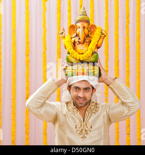 Uomo che porta una statua del signore Ganesha a Ganesh Chaturthi Foto Stock
