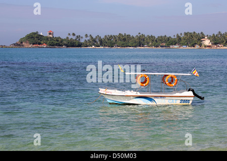 Piccola barca ancorata nel mare di Unawatuna Beach, Sri Lanka Foto Stock