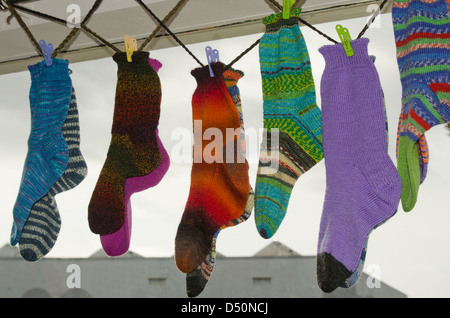 Varie coppia di calze di lana appendere in una finestra del negozio, gli acquirenti adescante pensando di inverno imminente freddo. Foto Stock