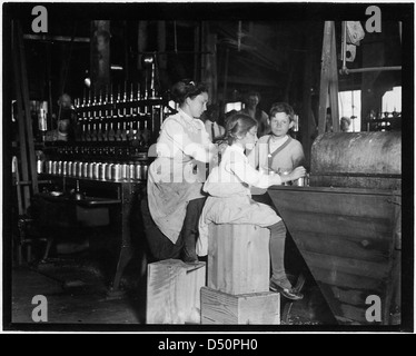 Daisy Langford, 8 anni, lavora sulle fabbriche di Ross, Seaford, Del. lei aiuta alla macchina di tappatura, ma non è ancora in grado di tenere il passo, giugno 1910 Foto Stock