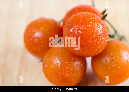 Mazzetto di rossi freschi pomodori ciliegia su sfondo di legno, closeup, il fuoco selettivo Foto Stock