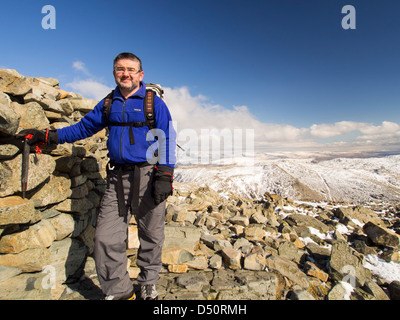 Un viandante sul vertice di Scafell Pike, Lake District, UK, il picco più alto in Inghilterra. Foto Stock