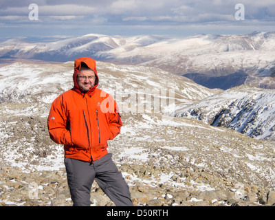 Un viandante sul vertice di Scafell Pike, Lake District, UK, il picco più alto in Inghilterra. Foto Stock