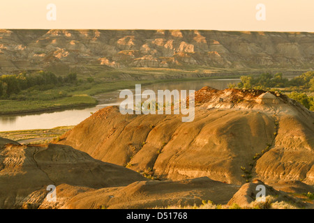 Le luci del tramonto il badlands confinanti con il cervo rosso fiume al Parco Provinciale dei Dinosauri in Alberta. Canada Foto Stock