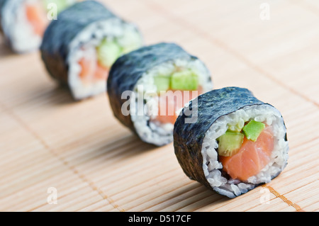 Sushi in fila sul tappetino di bambù Foto Stock