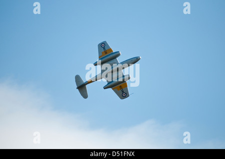 Uno dei primi anni cinquanta British aereo da combattimento visto dal di sotto, isolata, come vola sopra la testa contro un cielo blu. Foto Stock