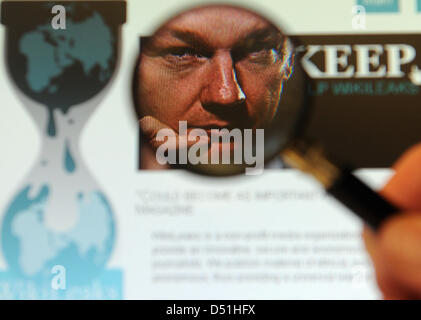 Una lente di ingrandimento mostra il volto di internet Austrialian attivista e fondatore di Wikileaks Julian Assange sul sito di Wikileaks a Berlino, Germania, 03 dicembre 2010. Aviazione statunitense ha bloccato l'accesso a media coinvolti, come 'New York Times', 'The Guardian' o 'Spiegel', dal loro computer, grazie ai documenti di Wikileaks. Foto: Britta Pedersen Foto Stock