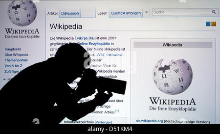 La figura mostra la sagoma di un uomo di scattare una foto della parola di Wikipedia su una sporgenza schermato del sito della enciclopedia online a Berlino, Germania, 22 dicembre 2010. Wikipedia celebra il suo decimo anniversario il 15 gennaio 2011. Foto: Robert Schlesinger Foto Stock