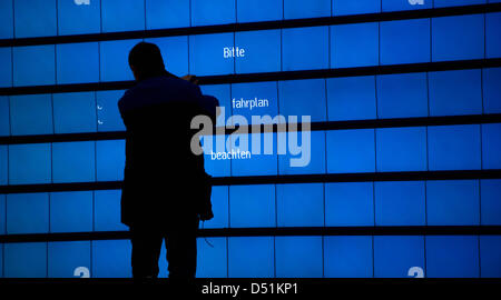 Un uomo si prepara un pannello di visualizzazione della Deutsche Bahn presso la stazione centrale di Dresda, Germania, 22 dicembre 2010. La Deutsche Bahn ha aumentato il numero di servizi ferroviari lungo le principali linee ferroviarie. L'operatore ferroviario tedesco è di rispondere al crescente numero di treno passeggeri che, alla luce delle attuali condizioni climatiche rigide, ha scelto di viaggiare in treno piuttosto che Foto Stock