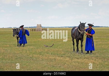 Mostra di equitazione da gulyas (pastori tradizionali / cowboy) che cavalcano cavalli ungheresi. Parco Nazionale di Hortobágy, Ungheria Foto Stock
