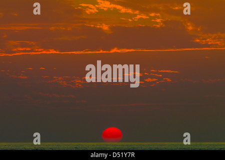 Tramonto in una densa foschia rivela enorme sun spot 1429 che ha minacciato di elettro-magnetico di interruzioni, Playa Guiones, Nosara, Costa Rica Foto Stock