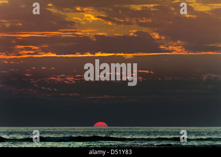 Tramonto in una densa foschia rivela enorme sun spot 1429 che ha minacciato di elettro-magnetico di interruzioni, Playa Guiones, Nosara, Costa Rica Foto Stock