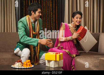 La donna il prelievo di una confezione regalo da un sacchetto di carta il Diwali Foto Stock