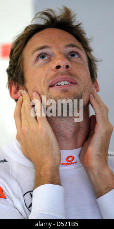 British driver di formula uno Jenson Button del team McLaren Mercedes guarda come si prepara per la terza sessione di prove libere del Gran Premio del Giappone sul circuito di Suzuka a Suzuka, in Giappone, 09 ottobre 2010. Il 2010 di Formula Uno Gran Premio del Giappone si terrà il 10 ottobre. Foto: Jens Buettner Foto Stock