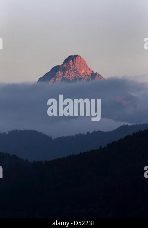 Rötlich leuchtet der 2047 Meter hohe Gipfel des Säulings am Sonntag (10.10.2010) bei Füssen (Schwaben) im Abendlicht, während die umliegendenTälern bereits im Schatten liegen. Auch in den kommenden Tagen kann laut Wettervorhersage in Bayern nach Auflösung von Nebelfeldern mit viel Sonnenschein gerechnet werden.Foto: Karl-Josef Hildenbrand dpa/lby Foto Stock