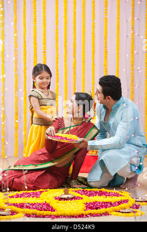 Famiglia Maharashtrian rendendo flower rangoli durante ganesh chaturthi festival Foto Stock