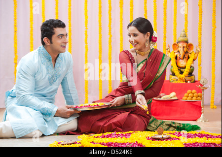 Maharashtrian giovane rendendo flower rangoli durante ganesh chaturthi festival Foto Stock