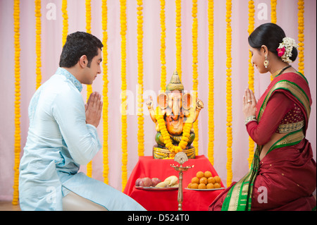 Maharashtrian giovane pregando Signore Ganesha durante ganesh chaturthi festival Foto Stock