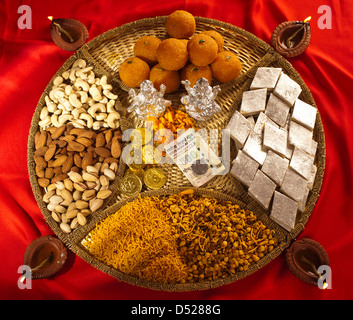 Un assortimento di Diwali dolci e snack con Diwali diyas Foto Stock