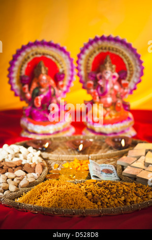 Diwali dolci e snack davanti agli idoli di Lakshmi e Ganesh durante il Diwali Festival Foto Stock