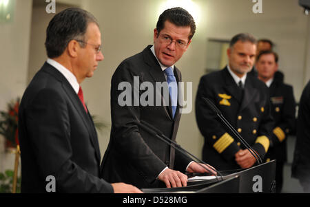 Frank-Juergen Weise (L), capo della Germania dell'agenzia federale per l'occupazione e capo della commissione speciale caricato con la ristrutturazione di forze armate tedesche, e il ministro della Difesa tedesco Karl-Theodor zu Guttenberg (2-L) presentare i risultati della relazione della commissione di Berlino, Germania, 26 ottobre 2010. La relazione propone di tagliare del Ministero della difesa personale da 3.300 a 1.600 e a sh Foto Stock